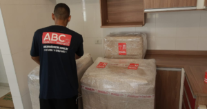 profissional da empresa de frete e mudanças ABC Mudanças preparando embalagem para móvel